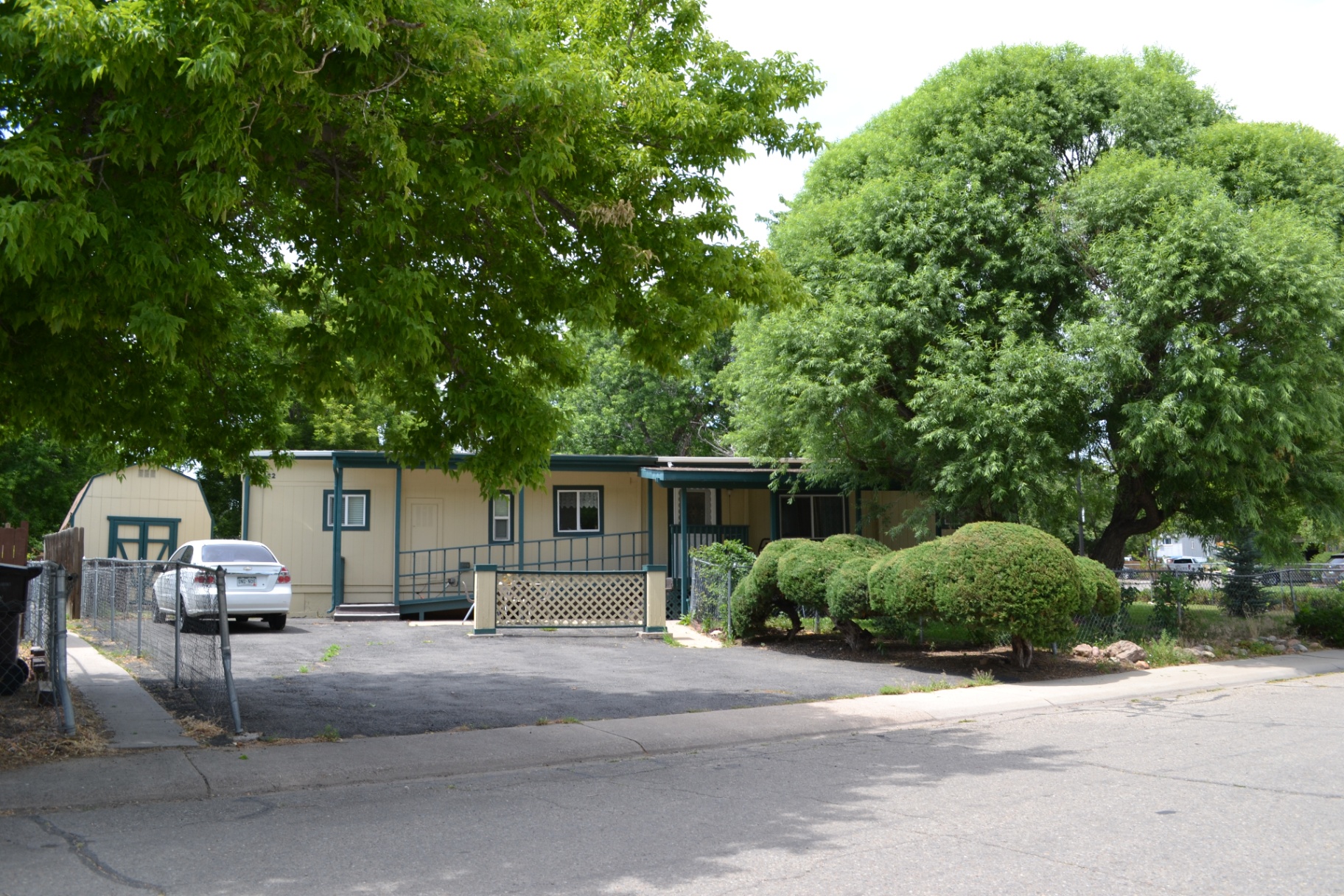 Corner lot on Walker — Teal accents, a wheelchair ramp, and a tidy storage shed on a well-kept parcel.